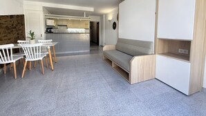 A modern living space with a kitchen, dining area, and a built-in sofa. - Agi Pi Sunyer 4 2D Apartamento for rent in Roses Girona. (Roses)