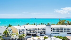 A coastal hotel with multiple balconies overlooking a marina and ocean. - OCEAN VIEWS 10A pool & Spa Wi-Fi (Airlie Beach)