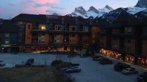 A multi-story hotel with a parking lot in front. - Family-Friendly Canmore Crossing Condo | Mountain Views | Sleeps 7 (Canmore)