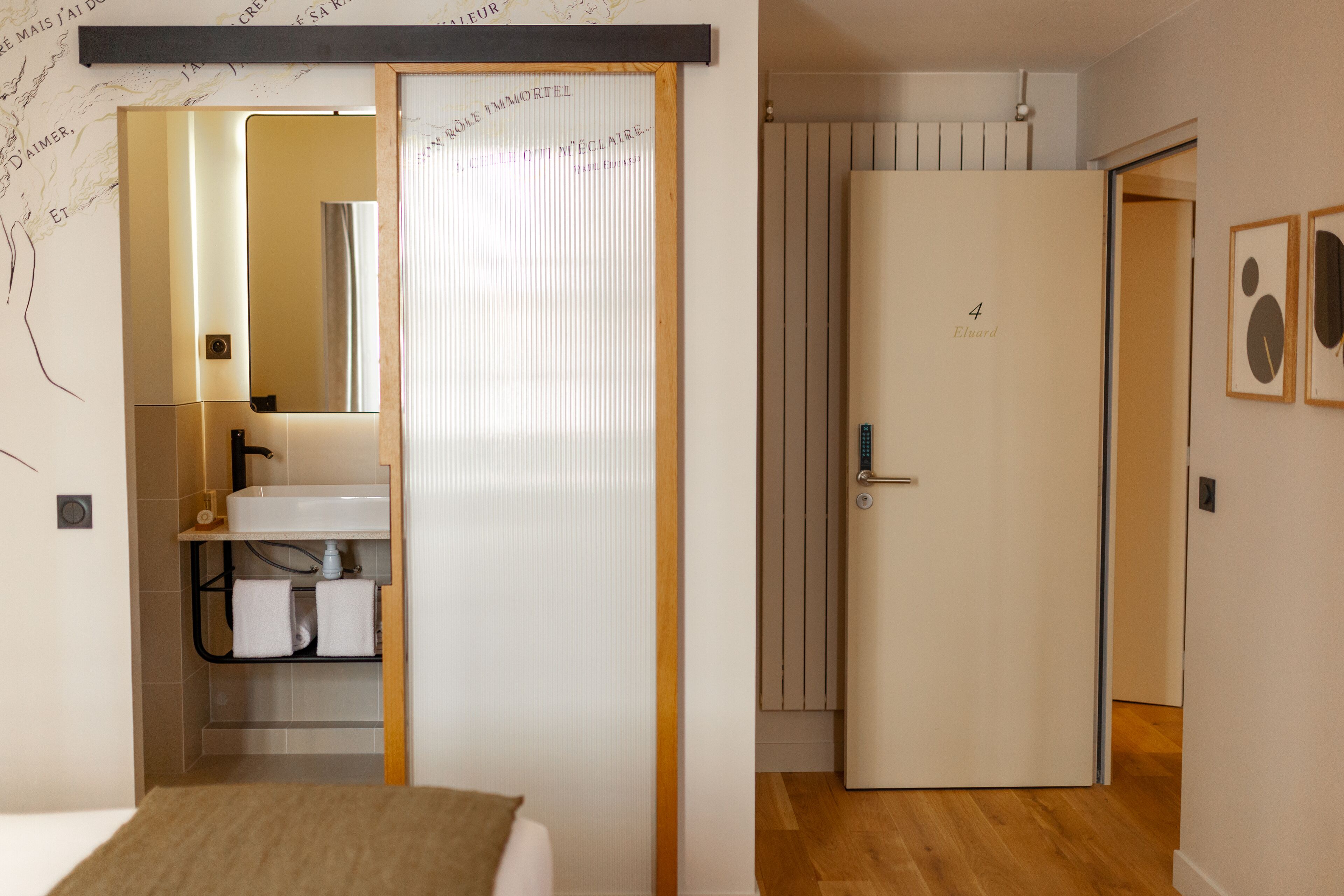 A hotel room with a bed, a bathroom with a sink, and a door leading to another room.