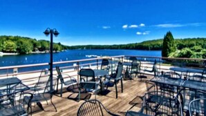 A deck with outdoor seating and a view of a lake.