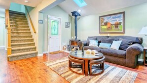 A living room with a staircase, a fireplace, a sofa, and a round coffee table.