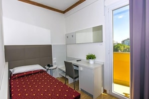 A hotel room with a bed, desk, chair, and a balcony with a view. - Hotel Mondial (Jesolo)