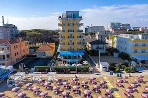 A hotel with a central courtyard, outdoor seating, and a pool area. - Hotel Mondial (Jesolo)