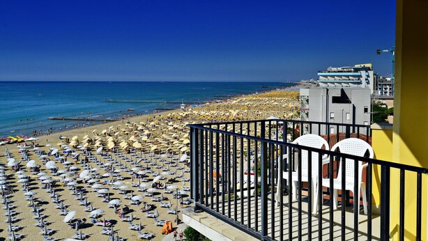 Un balcon avec vue sur une plage et la mer.