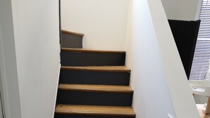 Una escalera con escalones de madera y barandilla de metal.