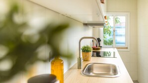 Eine moderne Küche mit einer Holz Arbeitsplatte, einer Edelstahl-Spüle und einem Fenster, das für natürliches Licht sorgt.