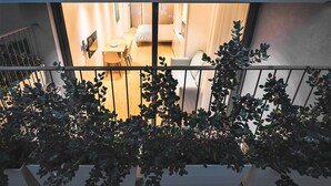 Ein Balkon mit Blick auf einen Raum, der ein Bett, einen Schreibtisch und einen Stuhl zeigt.
