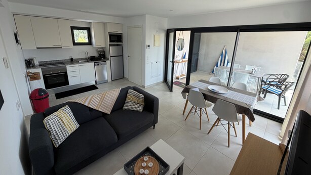 A modern living space with a kitchen, dining area, and a balcony with a view. - Modern apartment in superb residence with PISCINE-3 Min PLAGE ROSAS- Clim-Wifi (Roses)