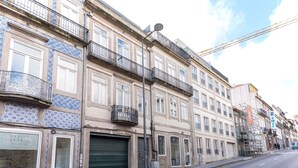 Une rangée d’immeubles à plusieurs étages dotés de balcons, une rue et un chantier de construction.