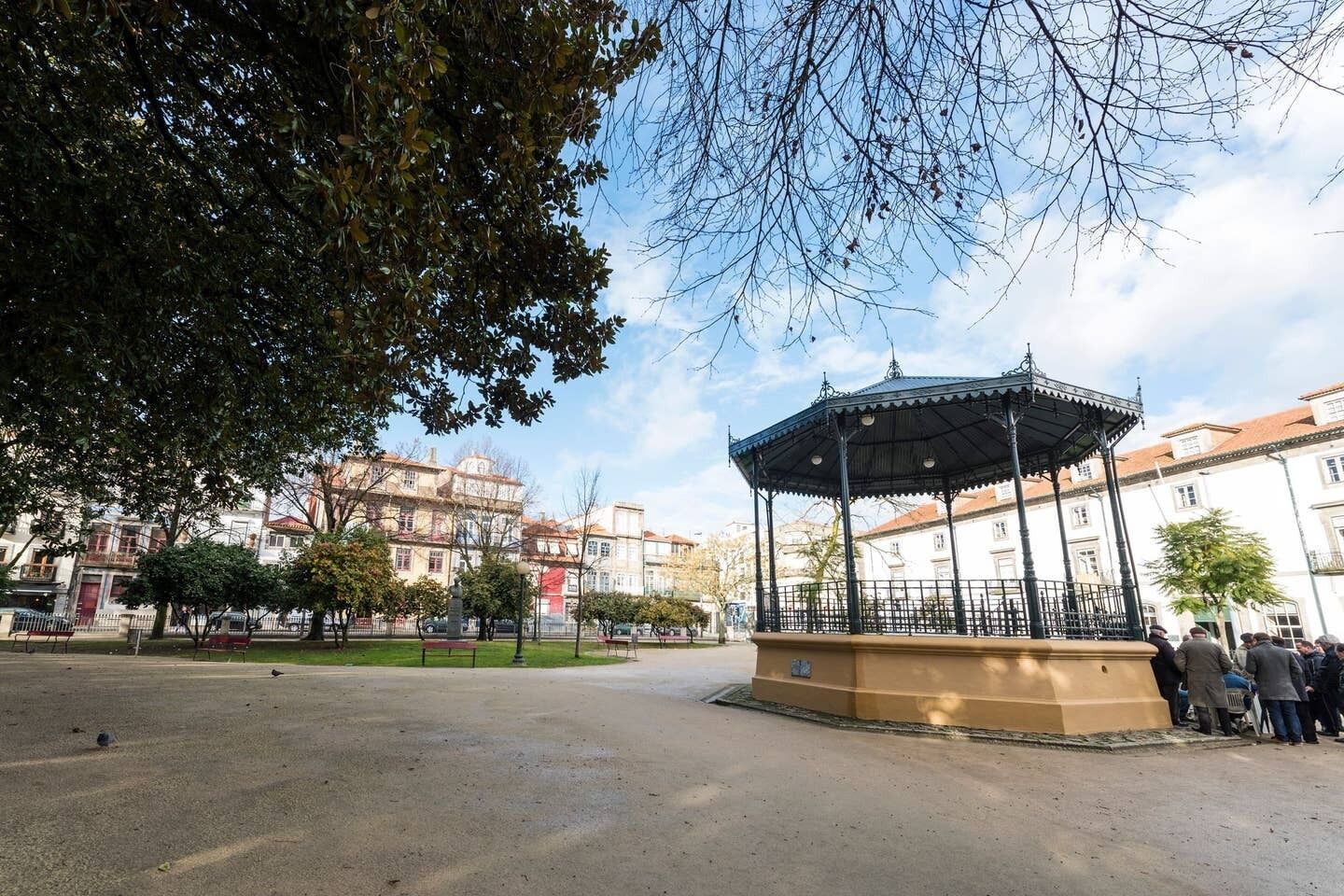 Un parque con un pabellón, bancos y una fuente.