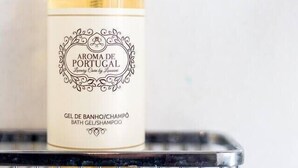 A bottle of 'Aroma de Portugal' bath gel on a metal shelf. - Jardins da Muralha Suite Downtown by DA'HOME (Porto)