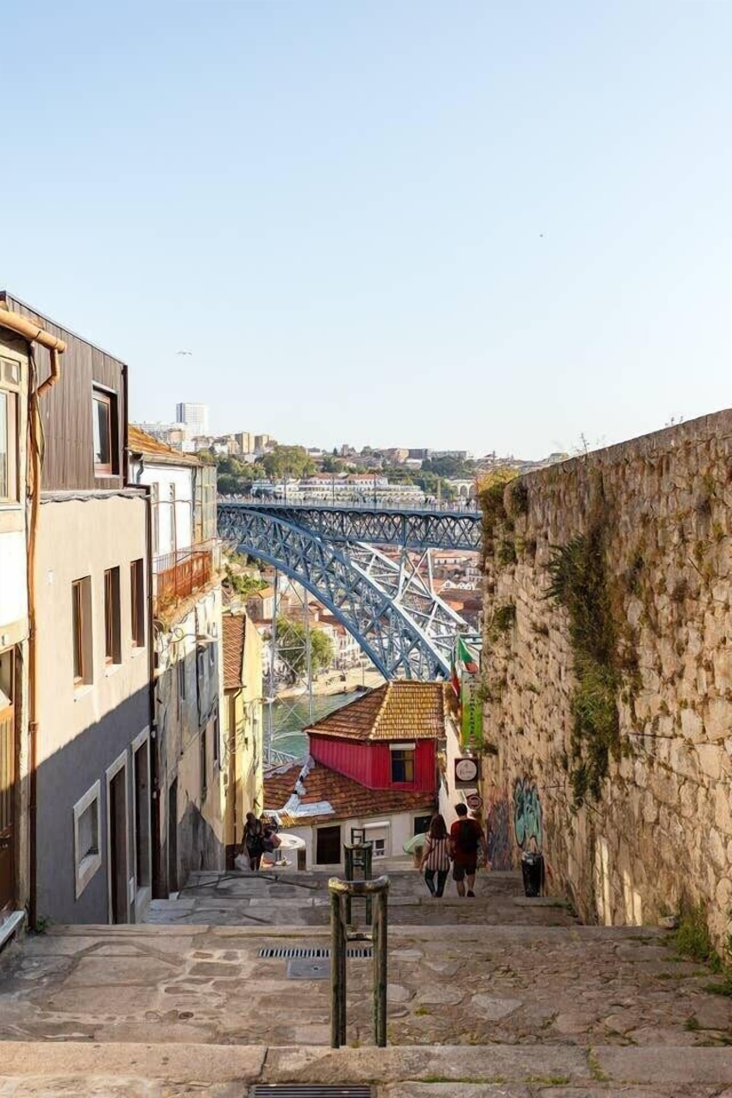 Una calle estrecha con escalones de piedra que conducen a un puente.