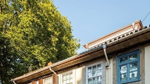 Een traditioneel gebouw met een straat van keien, een blauwe deur en een raam met een tralies.