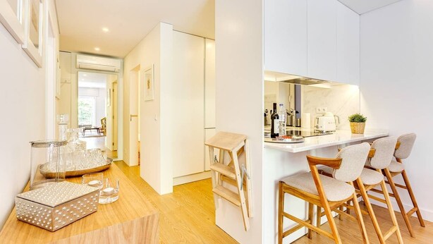 A modern kitchen with white cabinetry, a wooden countertop, and bar stools. - Wood Premium Downtown Apartment by DA'HOME (Porto)