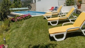 Una casa moderna con piscina e sdraio gialle.