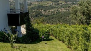 Una casa moderna con un balcone che si affaccia su una valle rigogliosa.