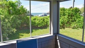 Una habitación con ventanas amplias que dan a un espacio verde y una masa de agua.