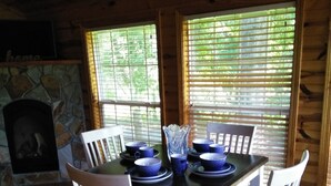 A dining area with a stone fireplace, wooden ceiling, and large windows with blinds. - Holidays are over!!! Come relax and unwind at Magnificent Views in Murphy!!! (Murphy)
