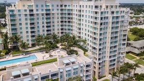 Un hôtel à plusieurs étages doté d’une piscine, de palmiers et offrant une vue sur le paysage environnant.