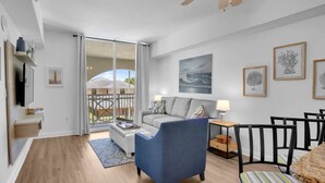 Un salon moderne avec un canapé, un fauteuil et un coin repas.