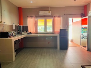 Kitchen area with central island, refrigerator, and countertop with appliances.
