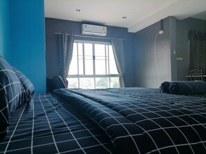 Relax in a spacious room with a large bed, air conditioning, and a convenient chair.