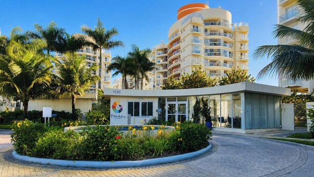 A modern hotel with a circular building, a landscaped garden, and a clear sky. - Nautilus Ap Vista Mar (Penha)
