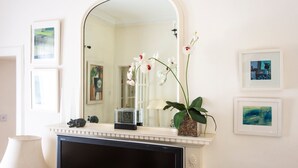 A bathroom with a white vanity, a mirror, a clock, and framed artwork on the wall. - GuestReady - Peaceful 2BR near Holyrood Park (Edinburgh)