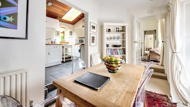 A modern kitchen with white cabinets, a wooden countertop, and a skylight. - GuestReady - Peaceful 2BR near Holyrood Park (Edinburgh)