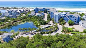 Un resort con varias edificaciones, un lago y una playa.