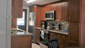 Une cuisine moderne avec des meubles en bois, des appareils en acier inoxydable et un dosseret carrelé.