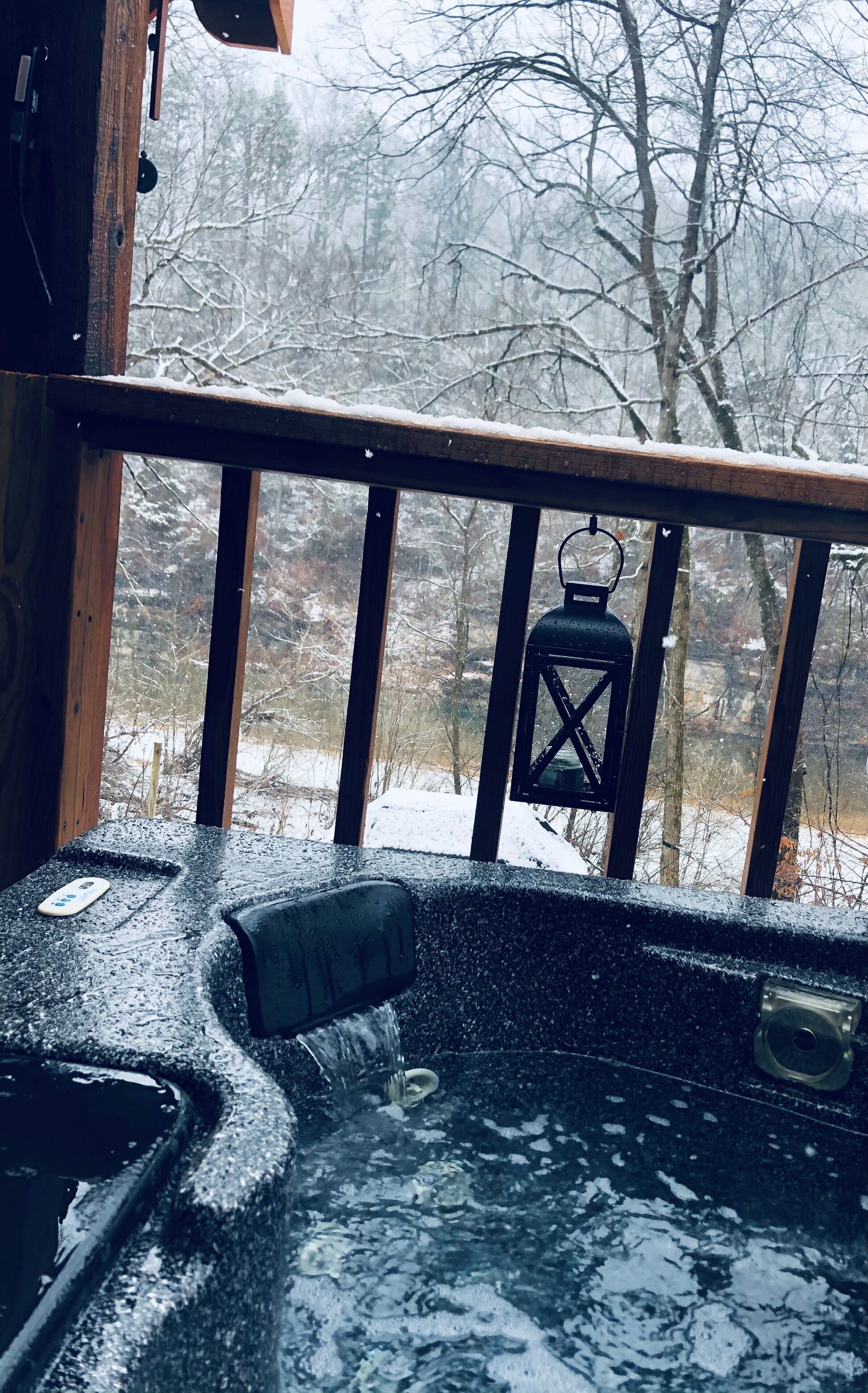 A wooden deck with a hot tub and a lantern.