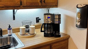Eine Küche mit Holzausstattung, einer Kaffeemaschine, einem Kaffeemühle und einer Kaffeetasse auf der Arbeitsfläche.