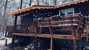 Eine Holzhütte mit Balkon, umgeben von Bäumen.