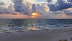 A beach with a sunset, clouds, and the ocean. - Luxury Beach House | Private Pool & Walk Everywhere (St. Pete Beach)