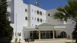 Um edifício branco com telhado verde e uma placa que diz 'HOTEL'.
