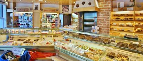 A bakery with various baked goods displayed in glass cases.