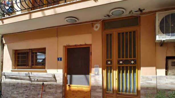 A residential building with a wooden door, a window, and a balcony.