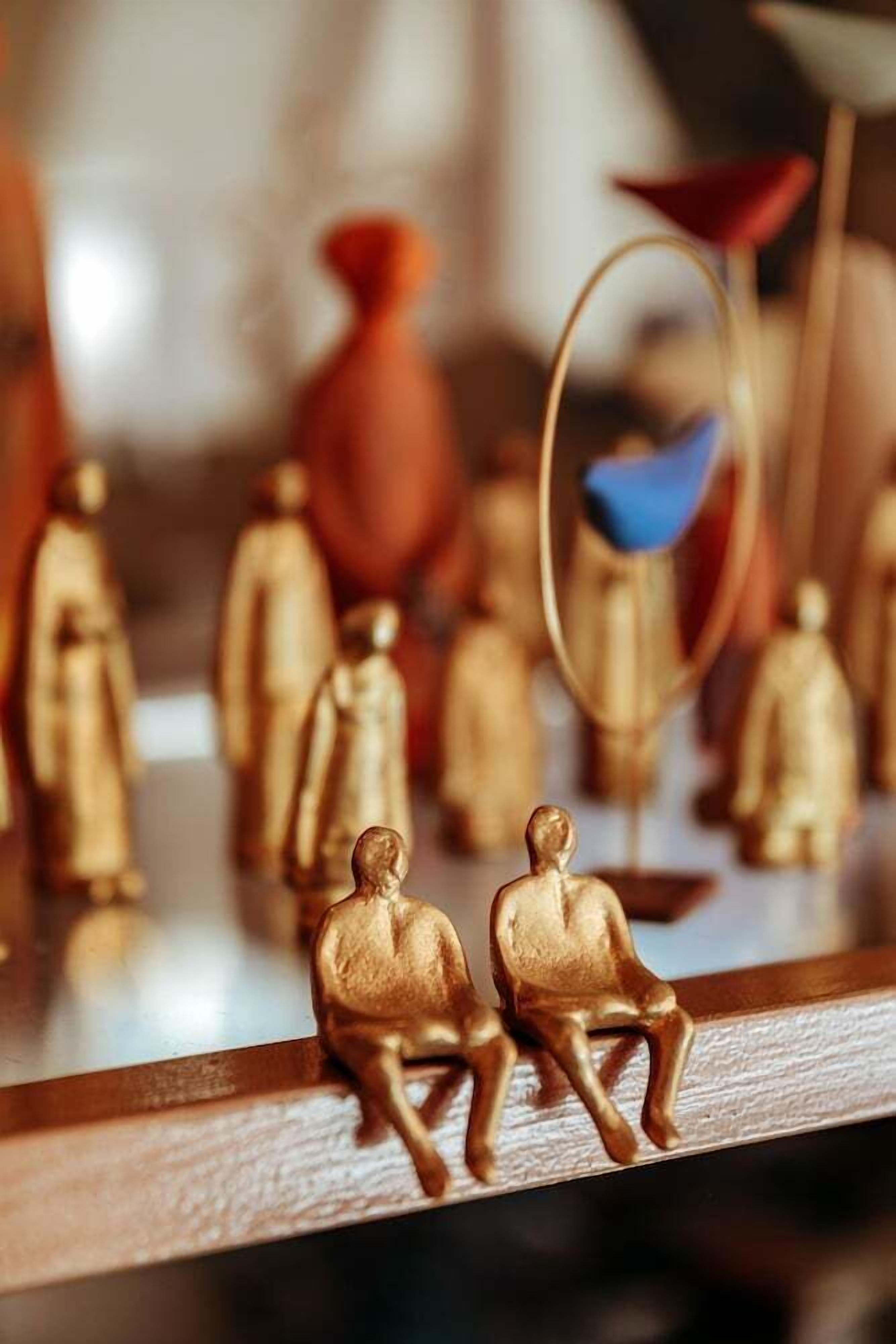 A reflective surface with golden figurines and a blue object.