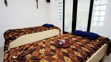 Cozy retreat with a comfortable bed, a small tray with a bowl, and a window offering a view of the outside.