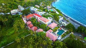 An aerial view of a coastal resort with multiple buildings, a swimming pool, and a beach. - Puri Saron Senggigi Beach Hotel (Senggigi)