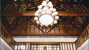 A lobby with a large chandelier, a central floral arrangement, and a high ceiling with wooden beams. - Puri Saron Senggigi Beach Hotel (Senggigi)