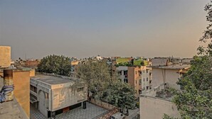 A rooftop with a flat surface, surrounded by buildings and trees. - The Le Grand (New Delhi)