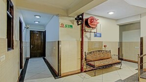 A hallway with a bench, a fire hose reel, and a sign indicating the 2nd floor. - The Le Grand (New Delhi)