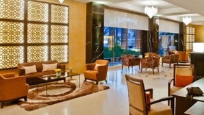 A modern hotel lobby with a central seating area, a bar, and large windows offering a view of the cityscape. - Four Points By Sheraton Dar Es Salaam New Africa (Dar es Salaam)