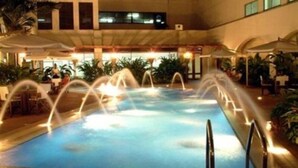 An indoor swimming pool with multiple fountains, surrounded by lounge areas and potted plants. - Four Points By Sheraton Dar Es Salaam New Africa (Dar es Salaam)