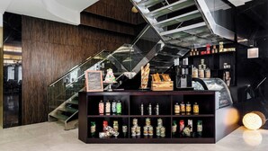 A modern interior with a staircase, a display of food items, and a sign indicating a bakery. - Four Points By Sheraton Dar Es Salaam New Africa (Dar es Salaam)