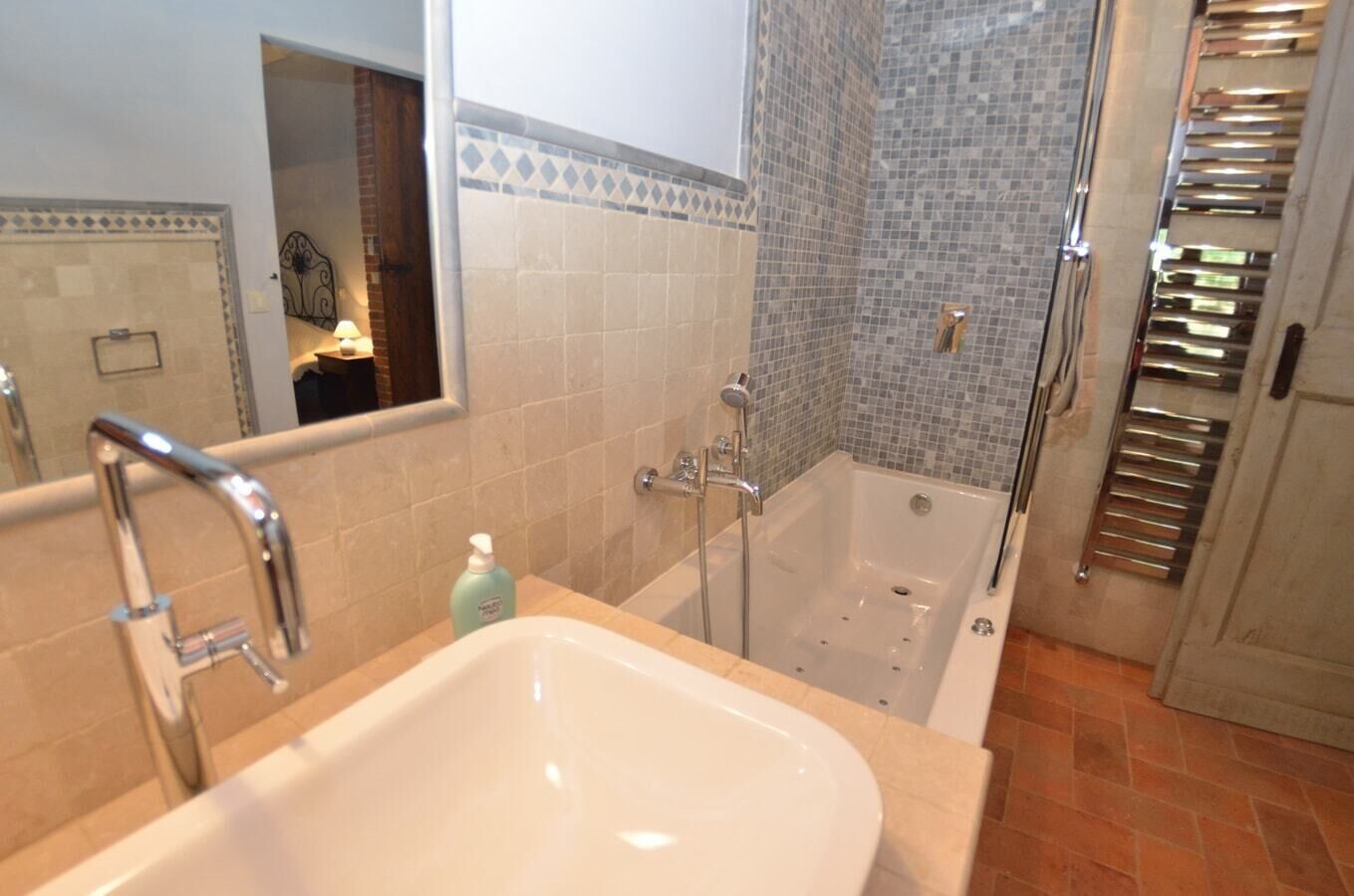 Een badkamer met een bad, een wastafel en een douche.