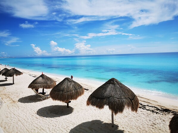 Privat strand, vit sandstrand, parasoller och strandhanddukar